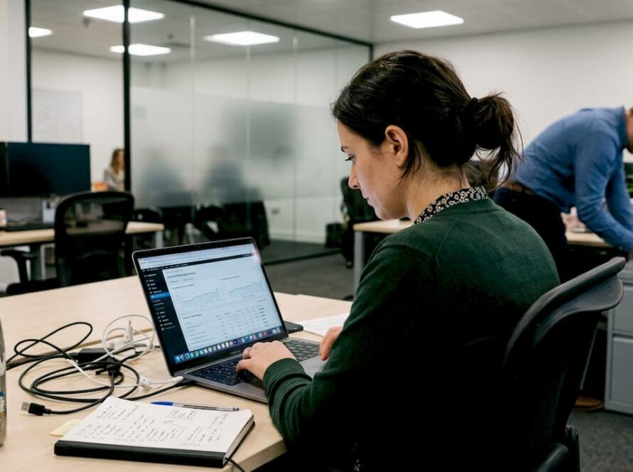 Agency employee reviews SEO report at busy office desk